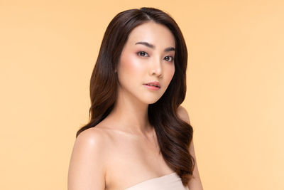 Portrait of a beautiful young woman over gray background