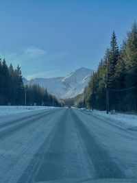 Empty road along snow covered landscape