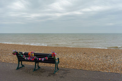 Lounge chairs on beach against sky