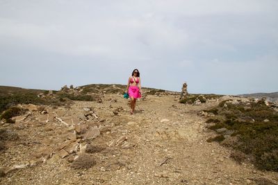 Woman walking on sand against sky at beach