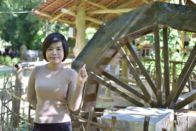 Portrait of smiling young woman against built structure