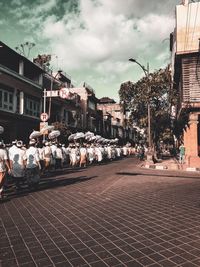 People on street against buildings in city