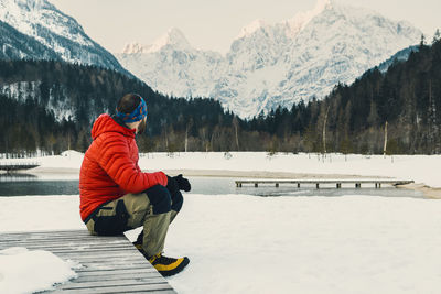 Man sitting on snowcapped mountains during winter