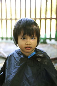 Portrait of little boy waiting for hair cut in back yard