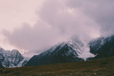 Scenic view of snowcapped mountain against cloudy sky