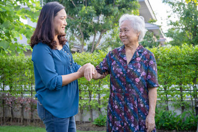 Side view of couple standing against trees