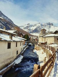 Snow covered buildings against sky
