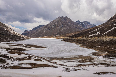 Frozen lake with mountain valley background in winter at day from flat angle