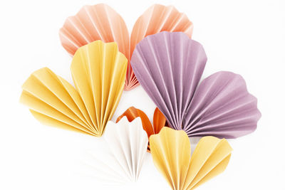 Pastel colored paper origami hearts arrangement on white background