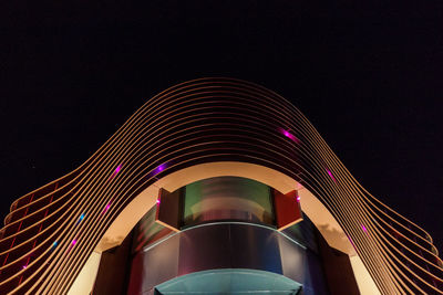 Low angle view of illuminated building against clear sky at night