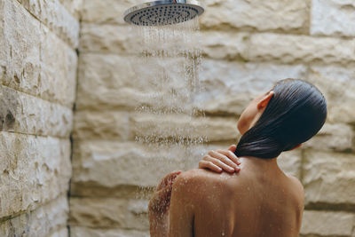 Rear view of man standing against wall