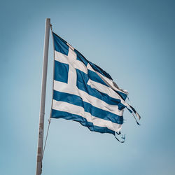 Low angle view of flag against clear blue sky