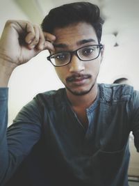 Close-up portrait of young man standing at home