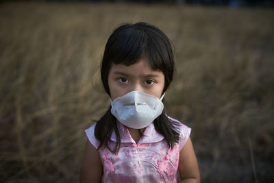 Portrait of girl wearing face mask standing outdoors