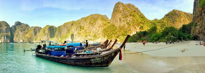 Boats moored on shore at beach in ko phi phi lee against sky