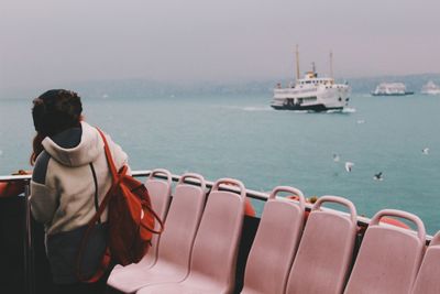 Rear view of man on ship in sea