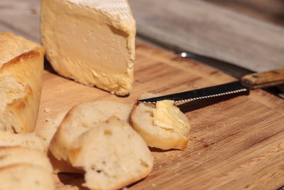 Close-up of cheese on bread at cutting board