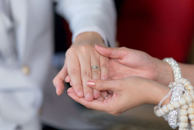 Close-up of newlywed couple holding hands
