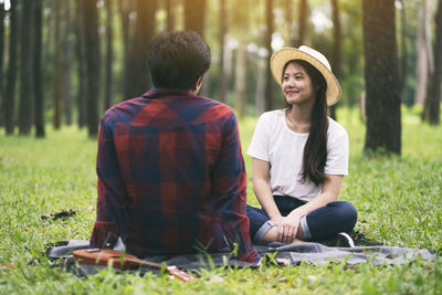 Rear view of couple sitting on land