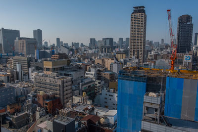 Aerial view of buildings in city against clear sky