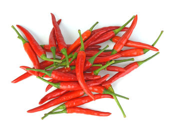 Close-up of red chili peppers against white background