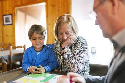 Grandparents playing ludo their grandson