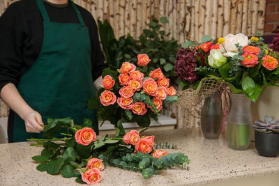 Midsection of man and rose bouquet