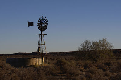 Low angle view of windmill on field against clear sky