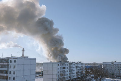 Smoke emitting from chimney against sky