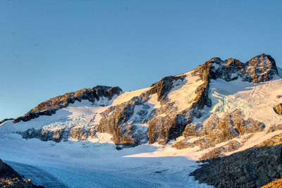 Scenic view of snowcapped mountains against clear blue sky