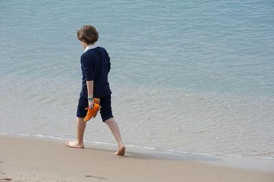 Rear view of boy standing on beach