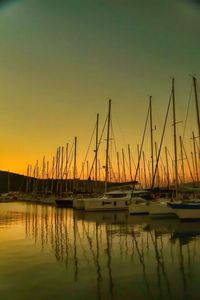 Sailboats in sea at sunset