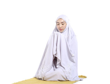 Young woman wearing mask against white background