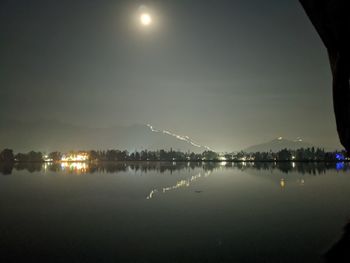 Scenic view of lake against sky at night