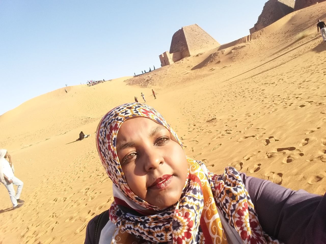 real people, land, sand, leisure activity, portrait, lifestyles, one person, headshot, nature, sky, front view, women, day, desert, arid climate, smiling, climate, beach, outdoors, innocence