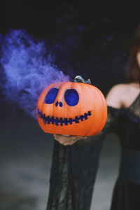 Midsection of woman holding jack o lantern