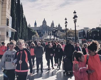 People on street in city against sky