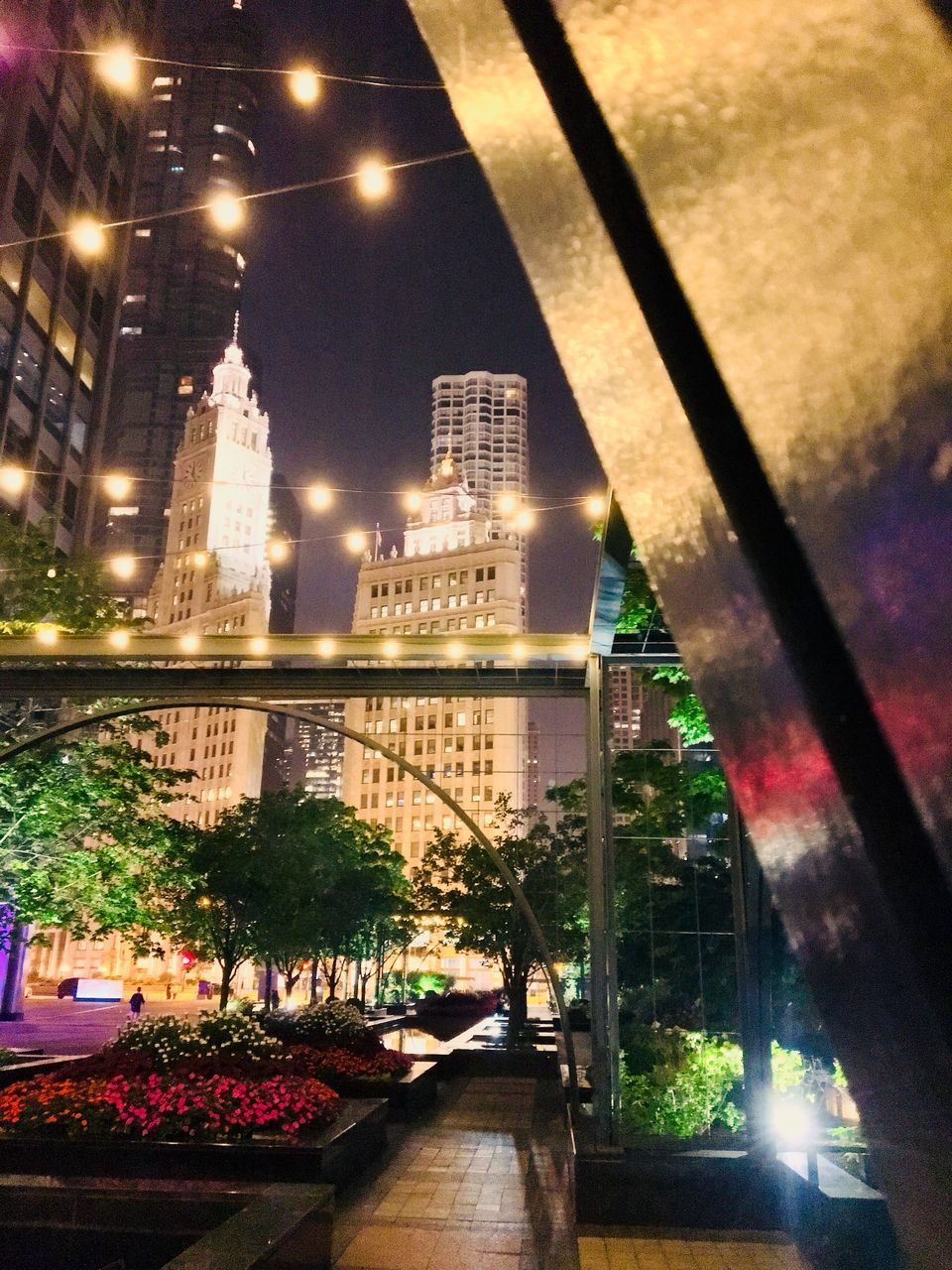 ILLUMINATED STREET AMIDST BUILDINGS AT NIGHT