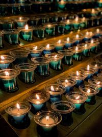 High angle view of lit candles on table in church