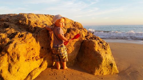 Child playing by rock at beach