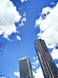 Low angle view of modern building against cloudy sky