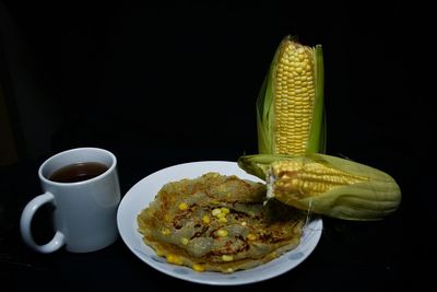 Close-up of coffee cup on table against black background