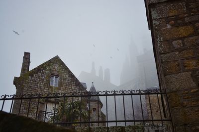Low angle view of castle during foggy weather