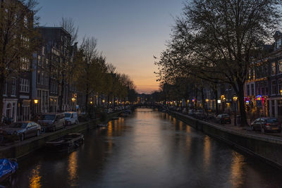 View of canal in city at dusk