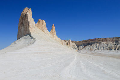 Rock formations on mountain against clear blue sky