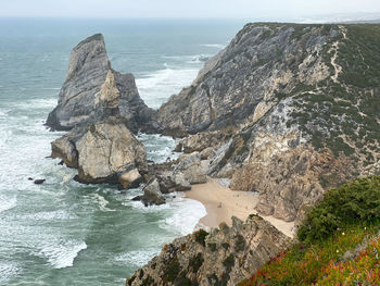 Scenic view of ocean and the rocks against sky