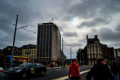 View of city street against cloudy sky