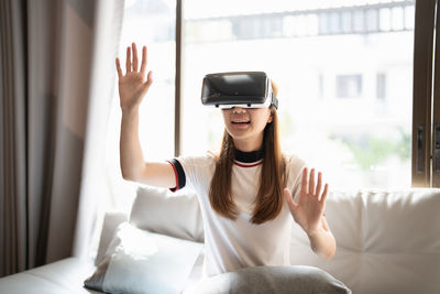 Girl gesturing wearing virtual reality headset at home