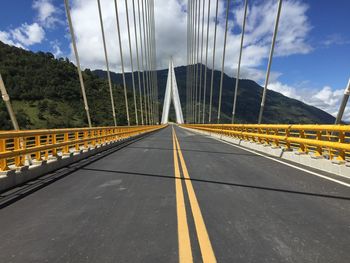 Road by bridge against sky