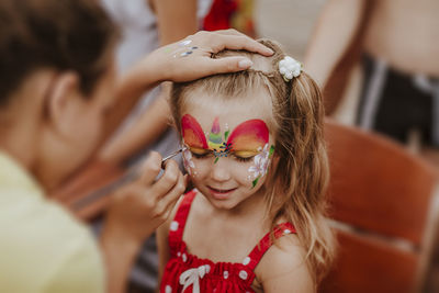 Artist painting on girl's face